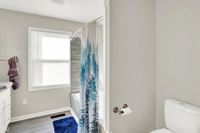 full bathroom featuring hardwood / wood-style flooring, vanity, toilet, and shower / bath combo with shower curtain