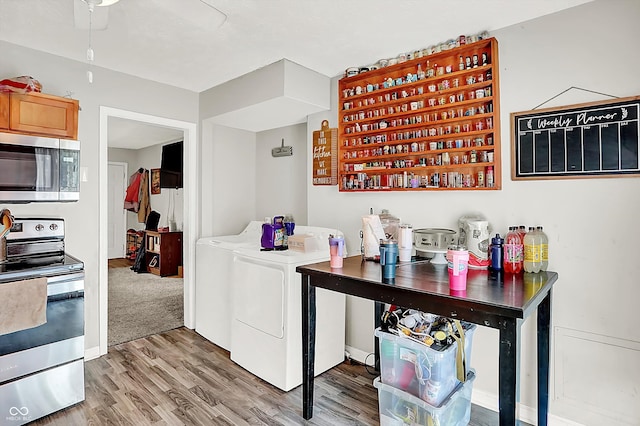 kitchen featuring wood-type flooring, washer and dryer, and appliances with stainless steel finishes