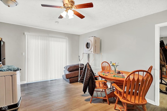 dining area featuring ceiling fan, light hardwood / wood-style floors, and a textured ceiling