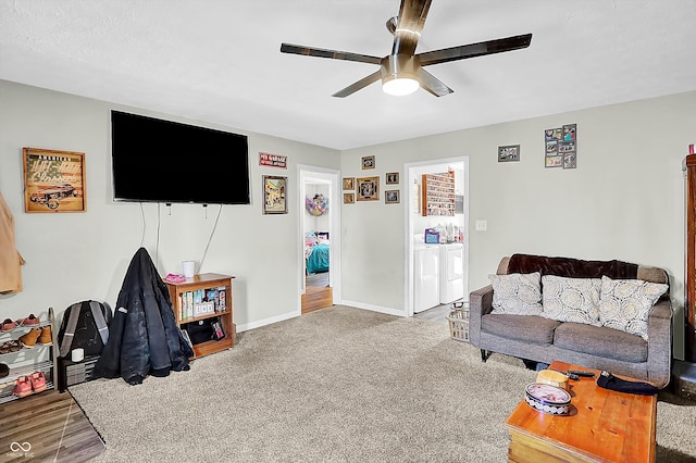 carpeted living room featuring separate washer and dryer and ceiling fan