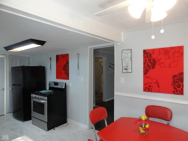 kitchen with stainless steel gas stove, fridge, and ceiling fan