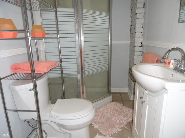 bathroom featuring tile patterned flooring, vanity, toilet, and a shower with shower door