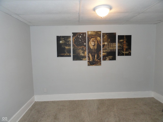 spare room featuring a paneled ceiling and carpet floors