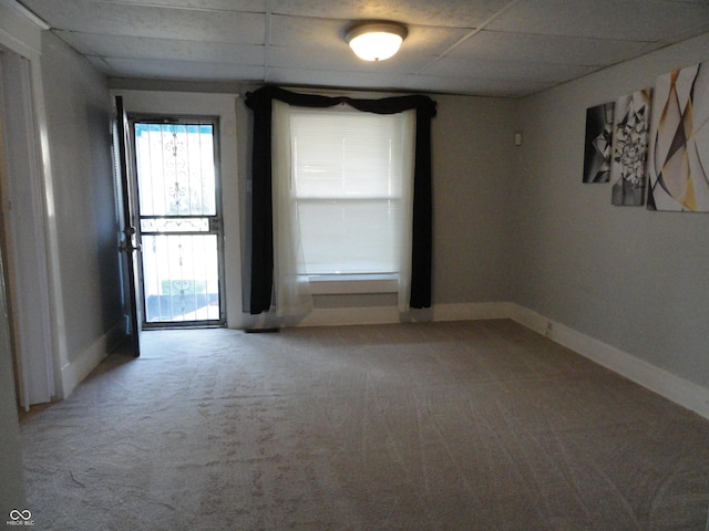 spare room featuring a paneled ceiling and carpet floors