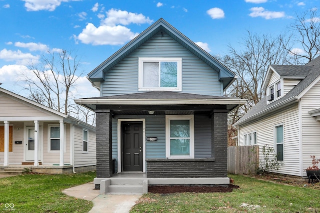 bungalow-style home featuring covered porch and a front lawn