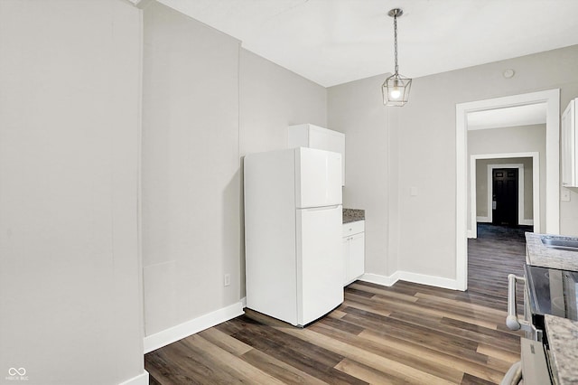 kitchen with white cabinetry, white fridge, pendant lighting, and dark hardwood / wood-style flooring