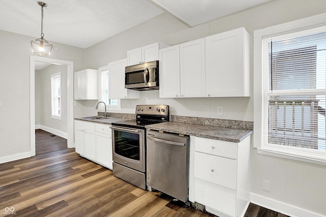 kitchen featuring white cabinetry, stainless steel appliances, sink, and pendant lighting