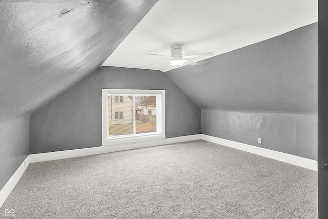 additional living space featuring vaulted ceiling, carpet floors, a textured ceiling, and ceiling fan