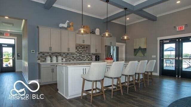 kitchen featuring french doors, stainless steel refrigerator with ice dispenser, dark hardwood / wood-style floors, decorative light fixtures, and a kitchen island