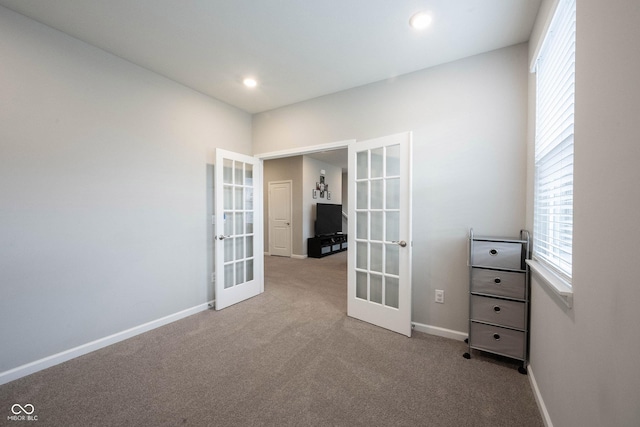 unfurnished room featuring french doors and light colored carpet