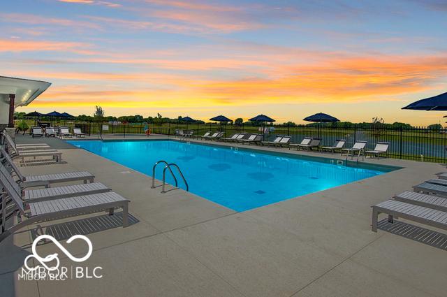 pool at dusk with a patio area