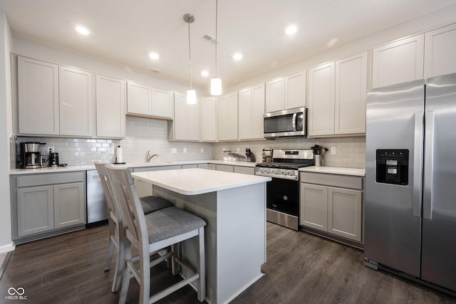 kitchen featuring decorative light fixtures, dark hardwood / wood-style flooring, stainless steel appliances, and tasteful backsplash