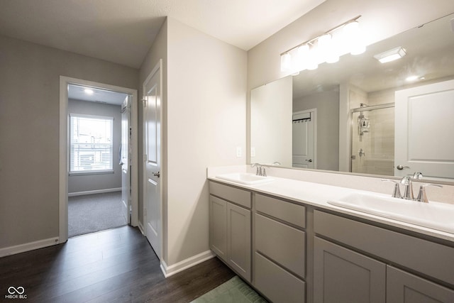 bathroom with wood-type flooring, vanity, and walk in shower