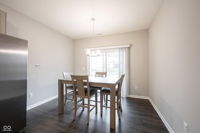 dining area with dark hardwood / wood-style flooring and a chandelier