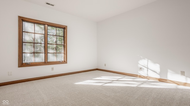 carpeted empty room with visible vents and baseboards