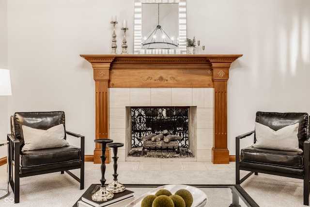 sitting room with baseboards and a tiled fireplace