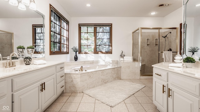 bathroom with tile patterned floors, two vanities, a stall shower, a sink, and a bath