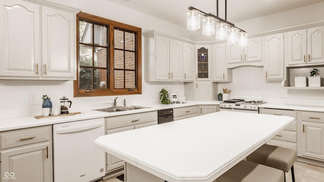 kitchen featuring tasteful backsplash, white appliances, a breakfast bar, and a sink