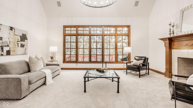 living area with lofted ceiling, a wealth of natural light, a fireplace, and carpet floors