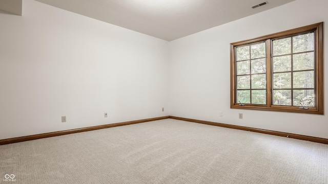 empty room featuring visible vents, baseboards, and carpet