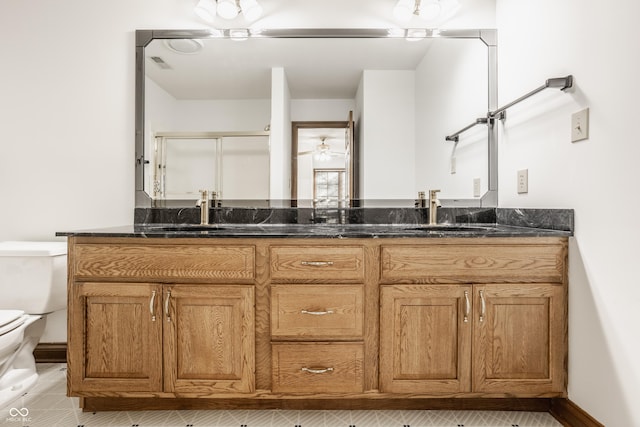 full bath featuring double vanity, visible vents, toilet, and a sink