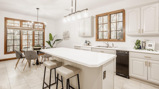 kitchen featuring a center island, pendant lighting, a breakfast bar area, light countertops, and a sink