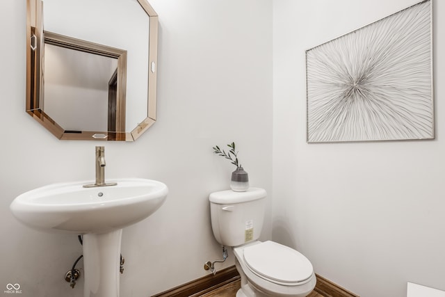 bathroom featuring baseboards and toilet