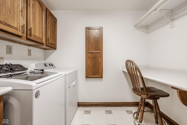 washroom featuring cabinet space, light floors, baseboards, and separate washer and dryer