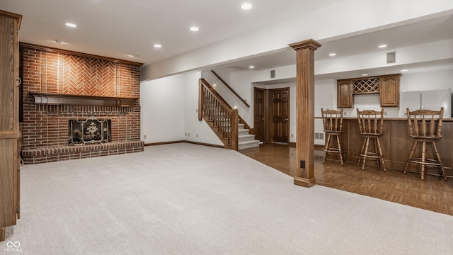 basement featuring bar area, baseboards, recessed lighting, a fireplace, and freestanding refrigerator