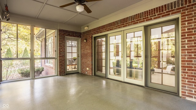 unfurnished sunroom with ceiling fan