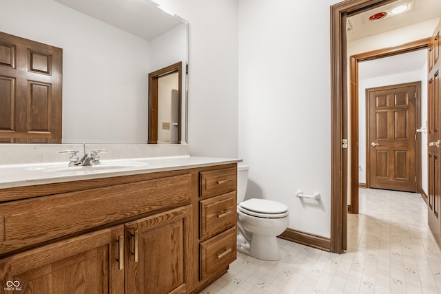 bathroom with tile patterned floors, toilet, vanity, and baseboards