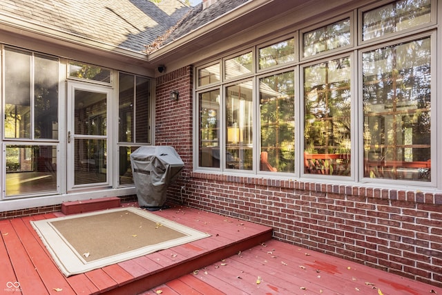 wooden terrace featuring grilling area and a sunroom