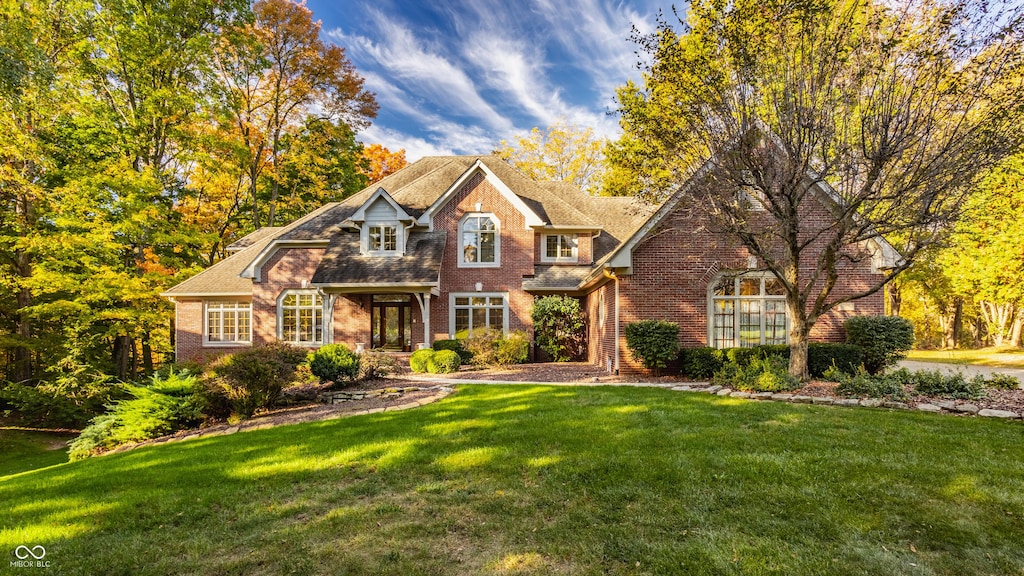 view of front of house featuring brick siding and a front lawn