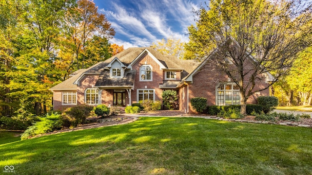 view of front of house featuring brick siding and a front lawn