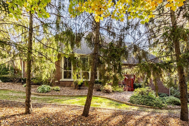 view of front of home with brick siding and a shingled roof