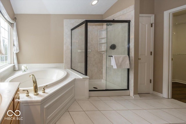 bathroom featuring tile patterned floors, plenty of natural light, independent shower and bath, and vanity