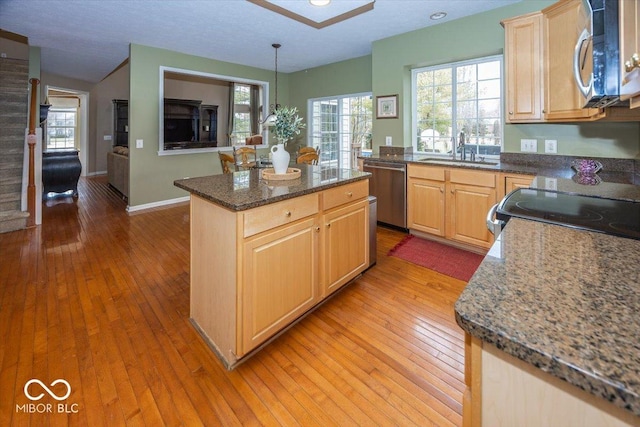 kitchen featuring pendant lighting, sink, appliances with stainless steel finishes, a kitchen island, and light brown cabinets