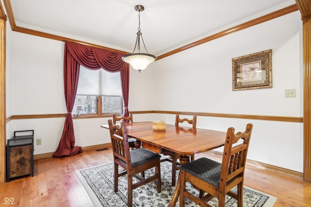 dining room featuring light hardwood / wood-style floors and ornamental molding