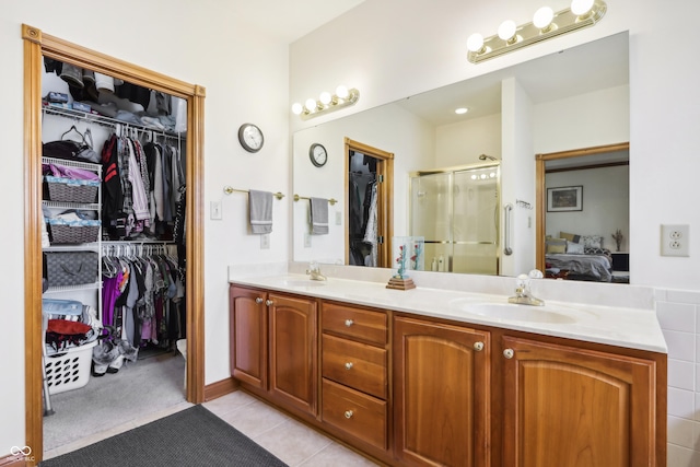 bathroom with tile patterned flooring, vanity, and a shower with shower door