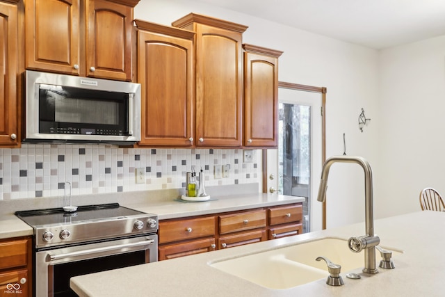 kitchen featuring decorative backsplash, stainless steel appliances, and sink