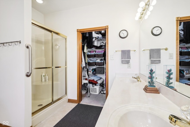 bathroom featuring a shower with door, vanity, and tile patterned flooring