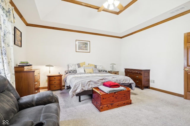 carpeted bedroom featuring ceiling fan, ornamental molding, and a tray ceiling