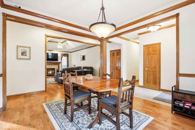 dining area with ornate columns, crown molding, light hardwood / wood-style flooring, and ceiling fan