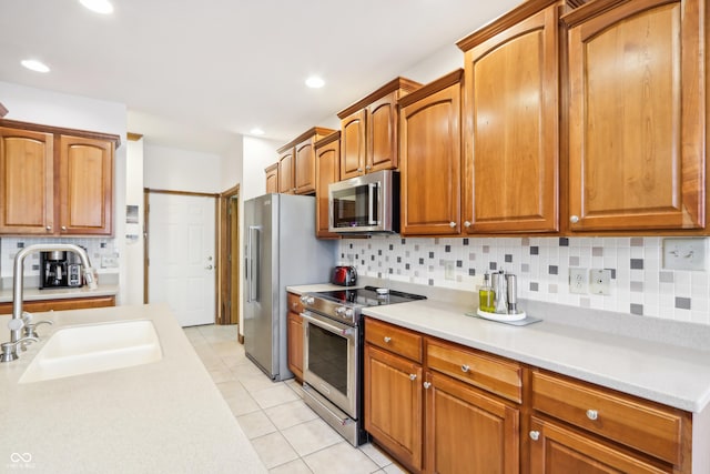 kitchen featuring decorative backsplash, sink, light tile patterned floors, and stainless steel appliances