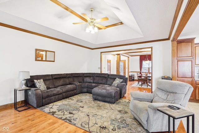 living room with ceiling fan, light hardwood / wood-style floors, crown molding, and a tray ceiling