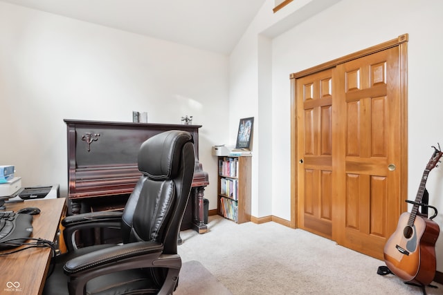 carpeted home office featuring lofted ceiling