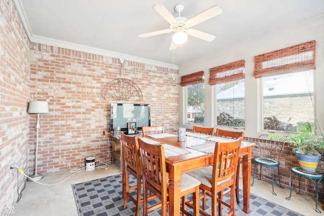 dining room with ceiling fan, crown molding, concrete flooring, and brick wall