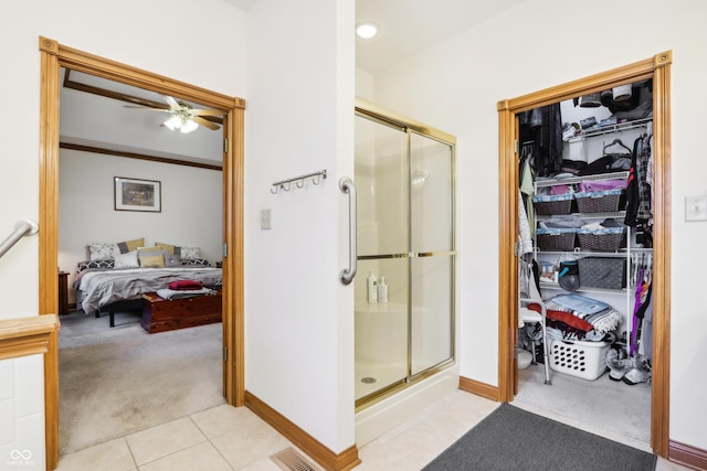 bathroom featuring tile patterned flooring, ceiling fan, and a shower with shower door