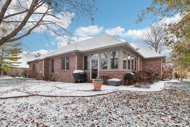 snow covered property featuring a sunroom