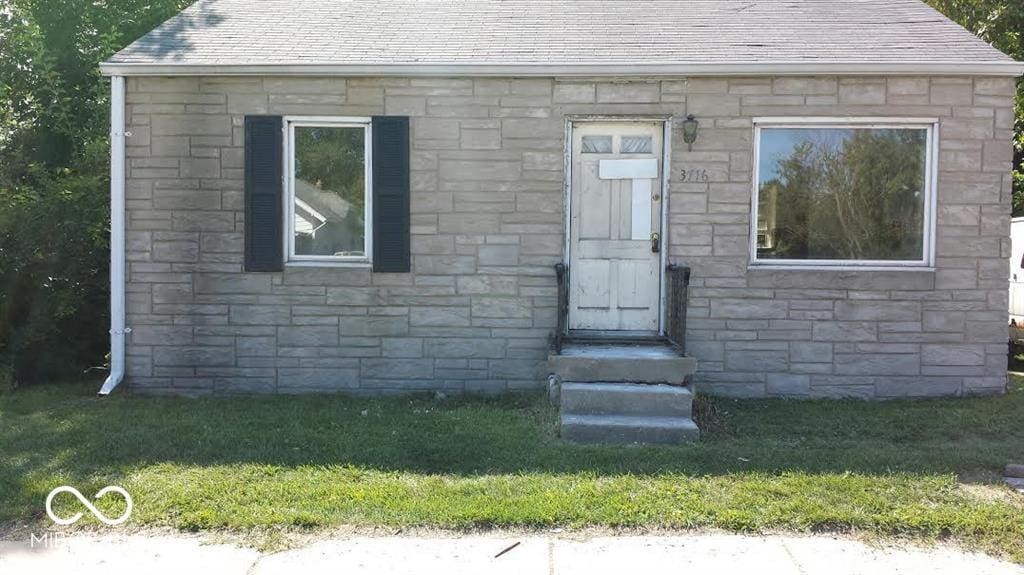 bungalow-style home featuring a front lawn